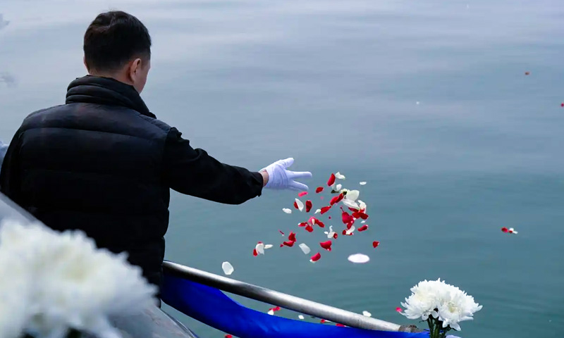逝者家属在完成骨灰海葬仪式后将花瓣撒向大海 逝者家属在完成骨灰海葬仪式后将花瓣撒向大海
