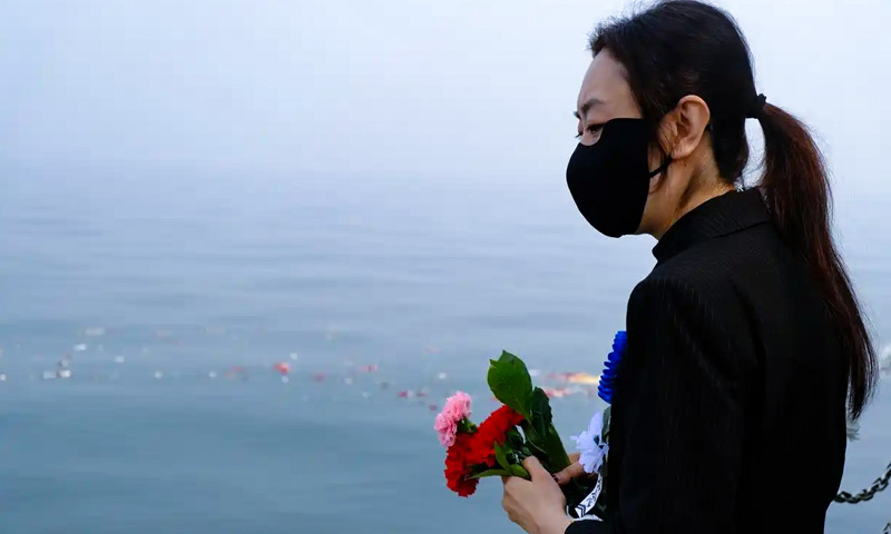 逝者家属在完成骨灰海葬仪式后驻足 逝者家属在完成骨灰海葬仪式后驻足
