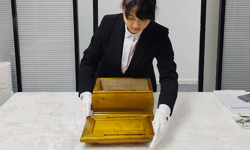 检查即将给家属送过去的骨灰盒